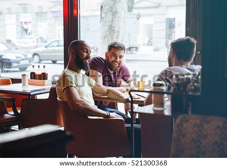 Happy male friends talking in beer pub
