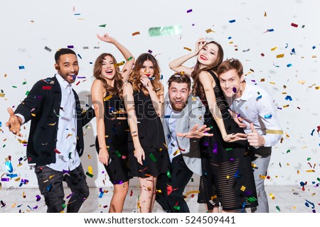 Group of happy young people celebrating and having fun together over white background