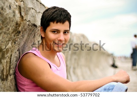 Glamour handsome teenager in pink t-shirt outdoors