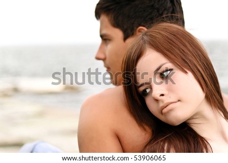 Young couple on the beach thinking