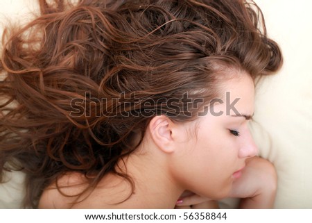 Photo of pretty long-haired woman sleeping peacefully in white bed
