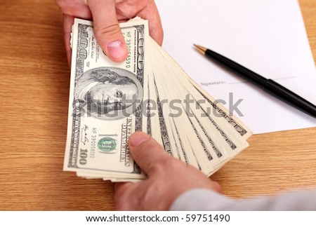 Businessmen passing money with contract on the background
