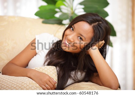 Beautiful asian woman with a smile relaxing on a sofa