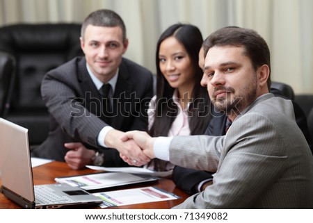 Multi ethnic business team at a meeting. Interacting. Focus on caucasian man in front
