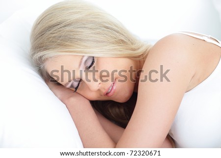 Young beautiful sleeping woman on the white pillow