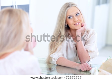 Young beautiful woman smiling to herself in mirror