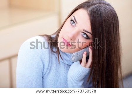 Portrait of a happy young woman on phone looking aside