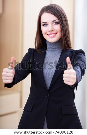 Happy successful businesswoman giving you thumbs up gesture