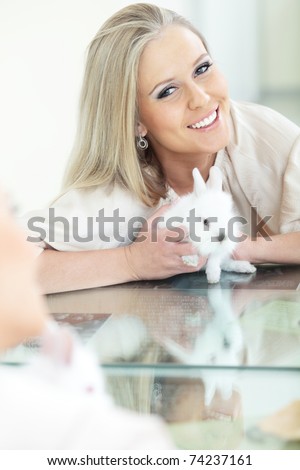 Young beautiful woman smiling to herself in mirror with rabbit
