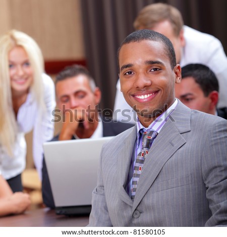 Young african-american businessman with his team working behind