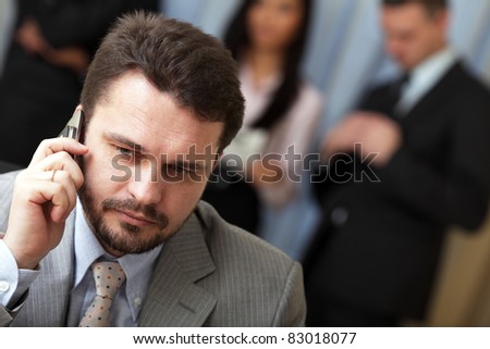 Portrait of a mature business man on phone in office environment