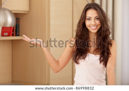 Smiling woman showing copy space for product with open hand palm