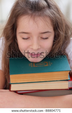 Schoolgirl dreaming on books with a soft smile