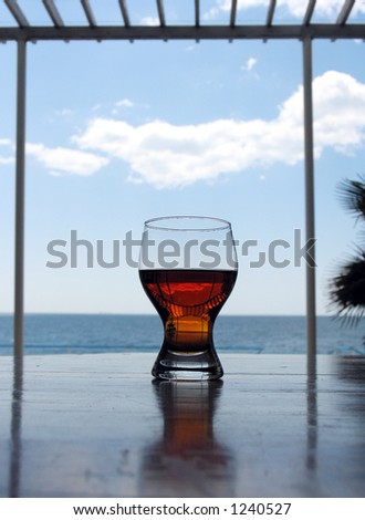 Glass with a wine on a background of the sea and the blue sky