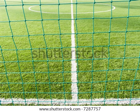 Field for game in football with a green grass and white lines a kind through a grid