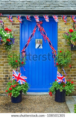 WINDSOR, UK - CIRCA JUNE 2012: Blue door decorated with an image of Queen Elizabeth II and union jack bunting for part of the Queens Diamond Jubilee celebrations circa June 2012.