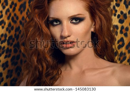 Sexy redhead woman over wall with leopard print