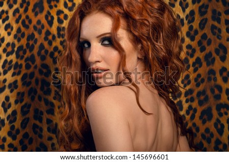 Sexy redhead woman over wall with leopard print