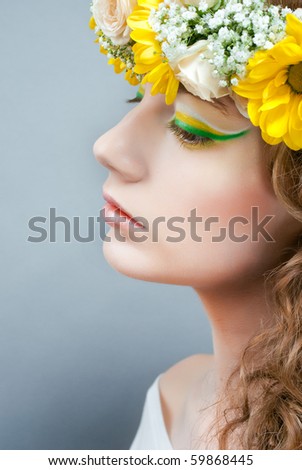 Studio portrait of young beautiful woman with flowers in hair