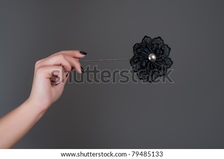 Black artificial flower in woman's hand