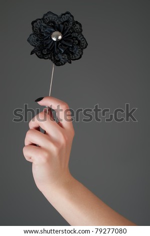 Black artificial flower in woman's hand