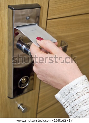 Hotel door - woman\'s hand inserting key card in an electronic lock