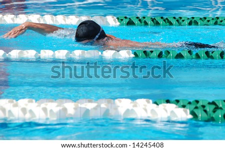 Man swims front crawl in swimming pool