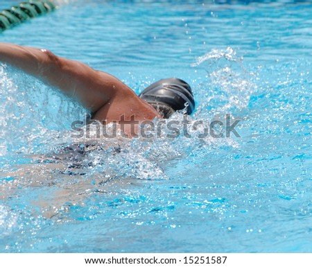Man swims front crawl laps in a swimming pool