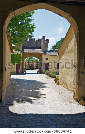 A stone arch leads to a courtyard in a chateau in France