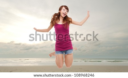 Happy woman jump at the ocean.