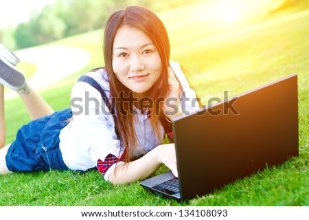 Beautiful Chinese girl on the lawn outside the computer