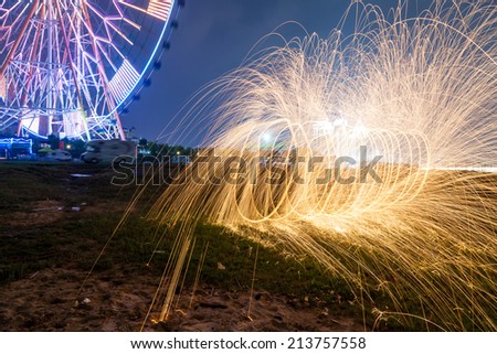 Abstract background with orange traces of hot campfire sparks on dark night blurred field.