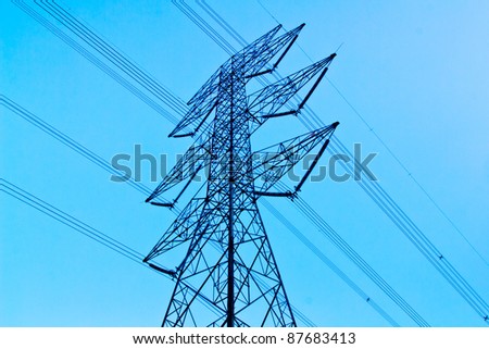 a long line of electrical transmission towers carrying high voltage lines.