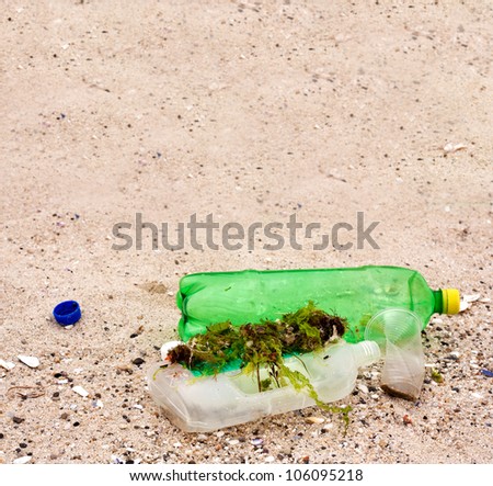 Pollution,environmental disaster.Plastic bottles and cup on the beach sand.Garbage