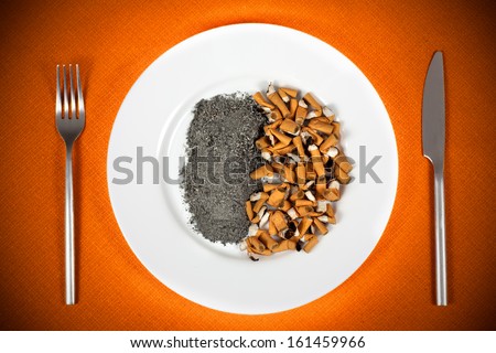 Cigarette butts or fags and ash in a plate.Smokers or smoking concept