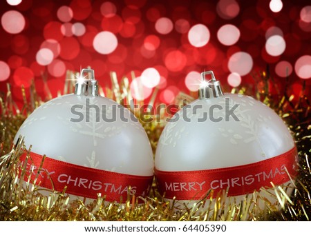 White Christmas baubles with Merry Christmas sign on background of defocused  lights  . Shallow DOF.