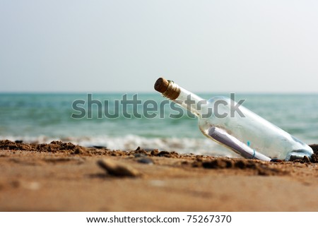 A Letter or message in a bottle on the shore,cast out by ocean or sea