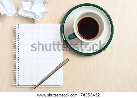 Pencil on a white notepad with cup of coffee on desk