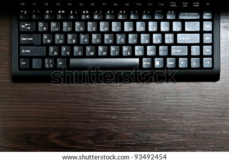 Single black keyboard on dark desk