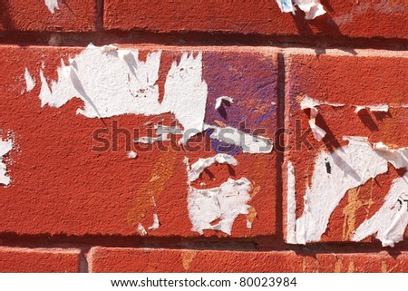 scraps of ad on brick wall