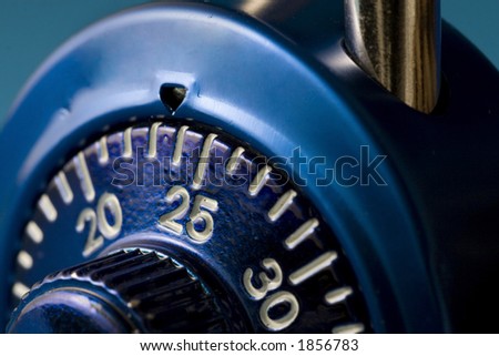 A macro (close up) image of a blue combination lock.  The number 25 is just past the tumbler and in sharp focus.