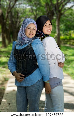 Asian muslim mum and daughter enjoying each others company in the park