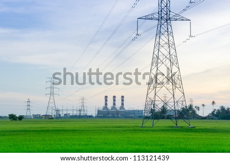 Electricity pylons with  power plant at the horizon