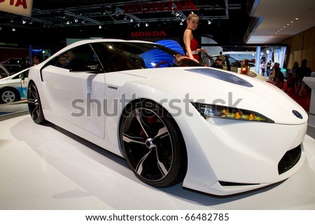 KUALA LUMPUR - DEC 3: An Asian Model poses with hybrid car from toyota, a concept car at International Motor Show 2010 on December 3, 2010 in Kuala Lumpur, Malaysia