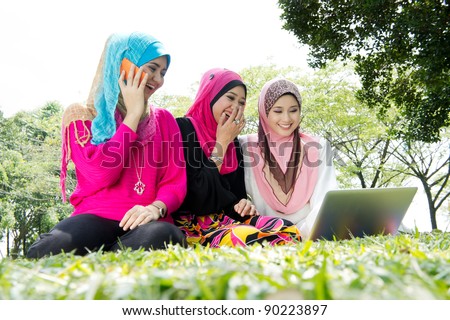 young muslim woman happy using laptop with friends