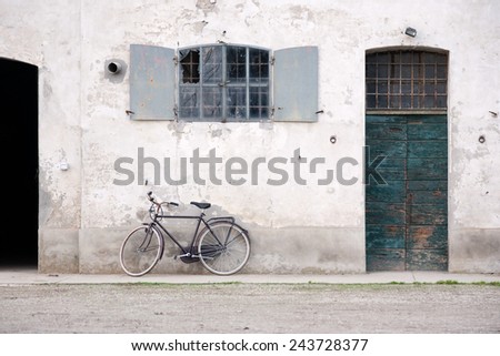 Bicycle rest in a wall of an old farmhouse. An typical italian bicycle rest in front of an old italian farmhouse in Romagna italian region, with laterally doors and central and up window.