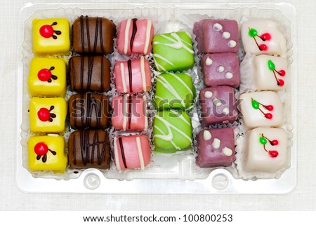 Colorful variety of mignon cakes in the box