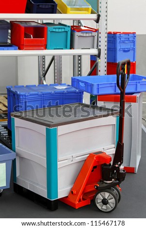 Plastic box at pallet truck in storage room