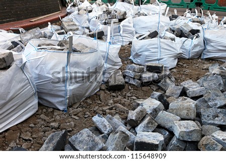 Reclaimed cobblestones in nylon bags at construction site
