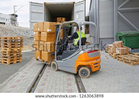 Loading Boxes at Pallet With Forklift in Cargo Container Train